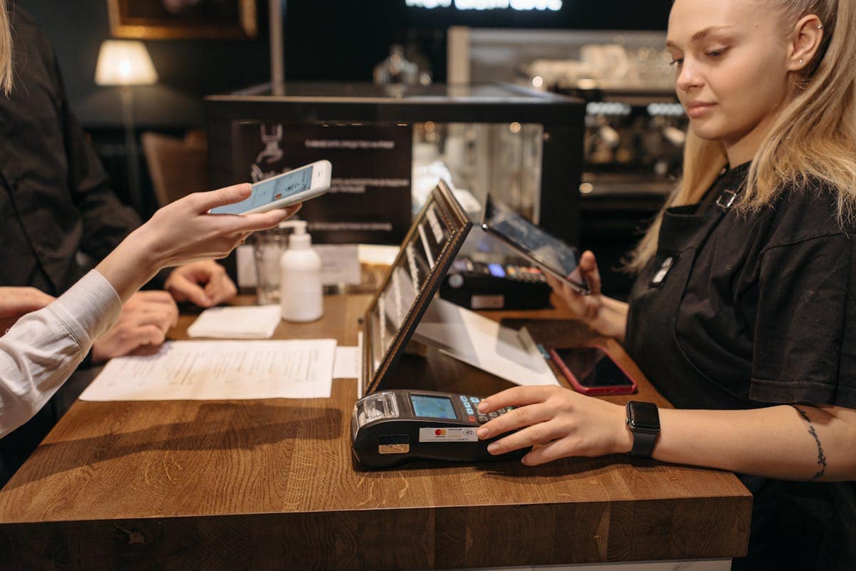 Customer using smartphone for contactless payment at counter